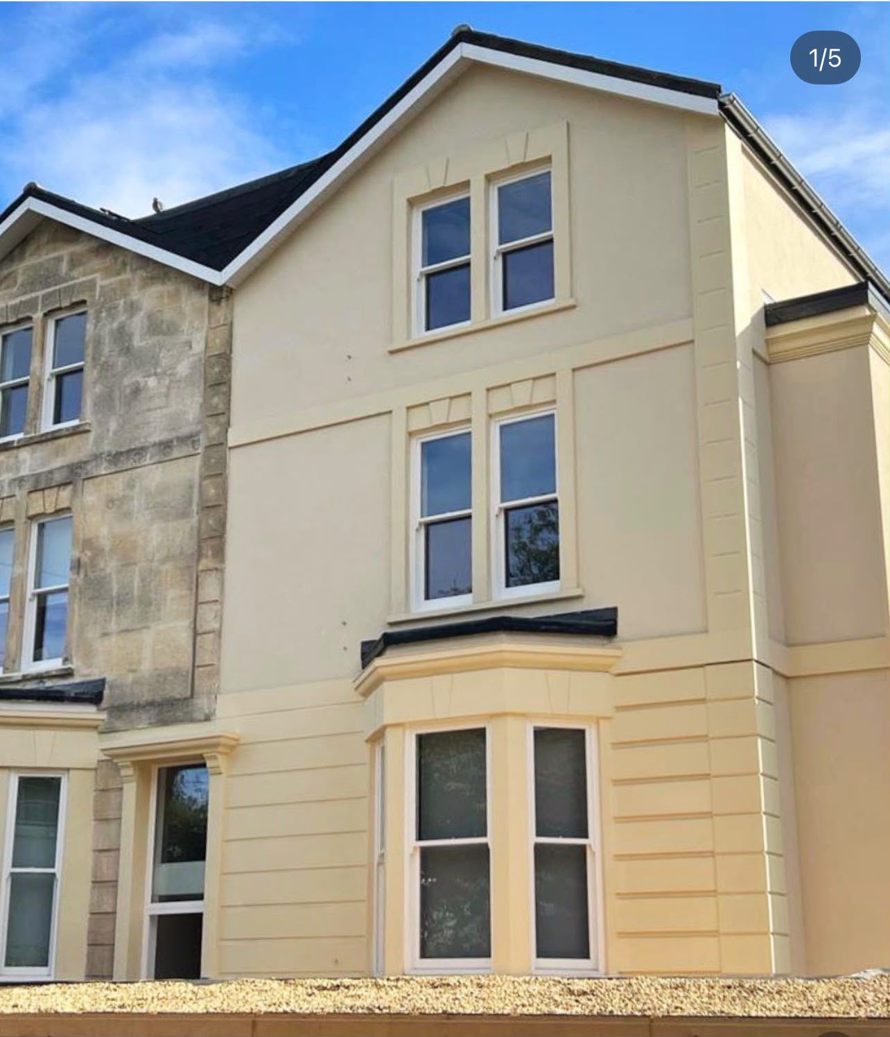 Victorian terraced house with cream rendered external wall insulation beside original stone facade